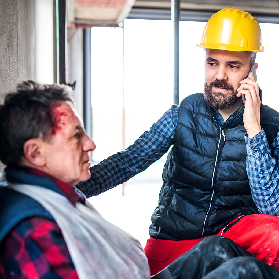 A construction worker sits at a job site holding a cloth to a cut on his forehead. Workers’ compensation for head injuries covers many types of head trauma that you can suffer on the job.