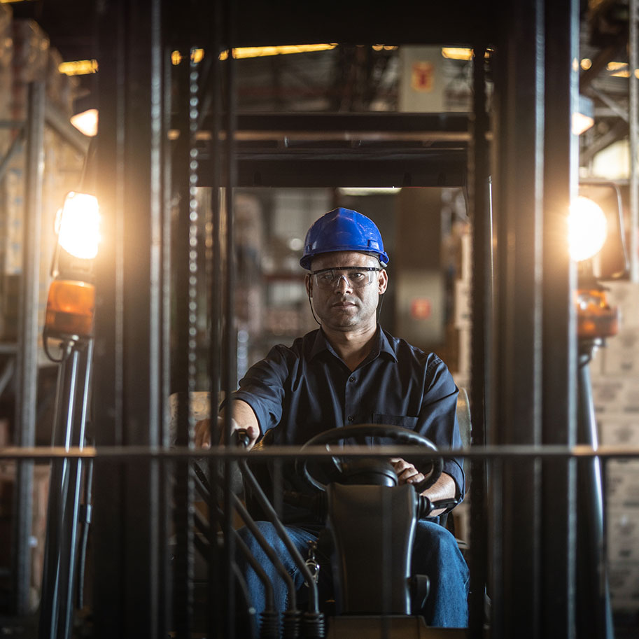 A man sits at the wheel of a forklift in a warehouse. Get help navigating the workers’ comp process from the manufacturing employees’ workers’ compensation lawyers at Horenstein, Nicholson & Blumenthal.