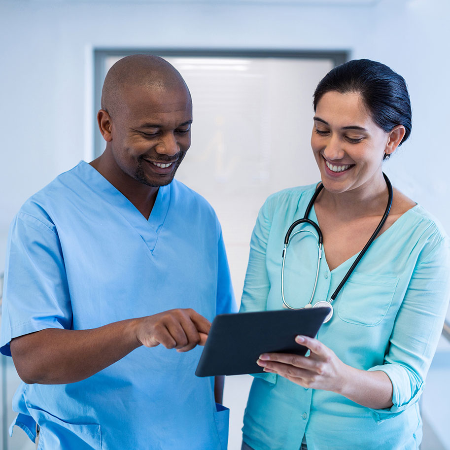 A man in scrubs looks at a tablet computer held by a woman with a stethoscope. The medical professionals’ workers’ compensation lawyers at Horenstein, Nicholson & Blumenthal fight for all the benefits due to you.