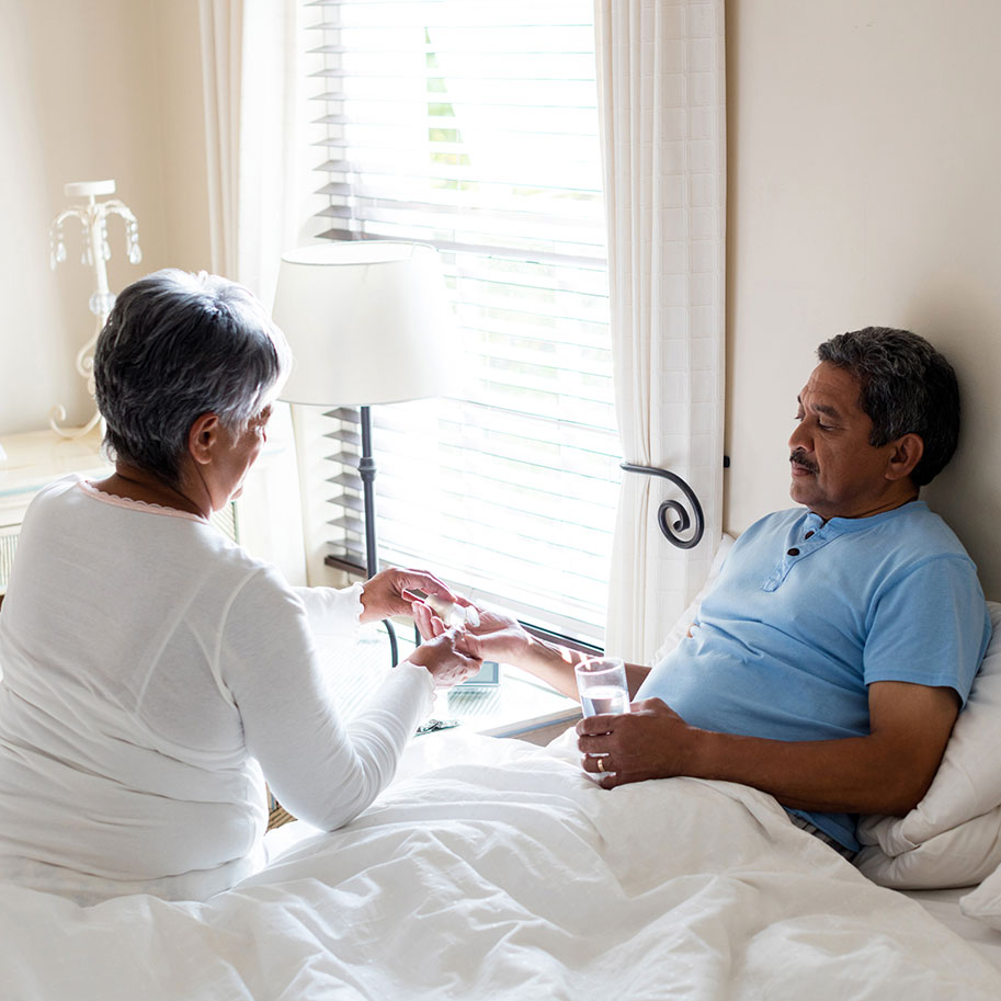 A woman gives pills to a man lying in bed. You can receive various forms of payment for harm caused by bad prescriptions. Talk to the Ohio prescription negligence lawyers at HNB.