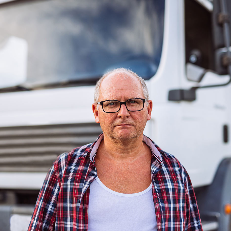 A man stands in front of a cargo truck. In the face of job hazards, the workers’ compensation lawyers at Horenstein, Nicholson & Blumenthal support transportation workers.