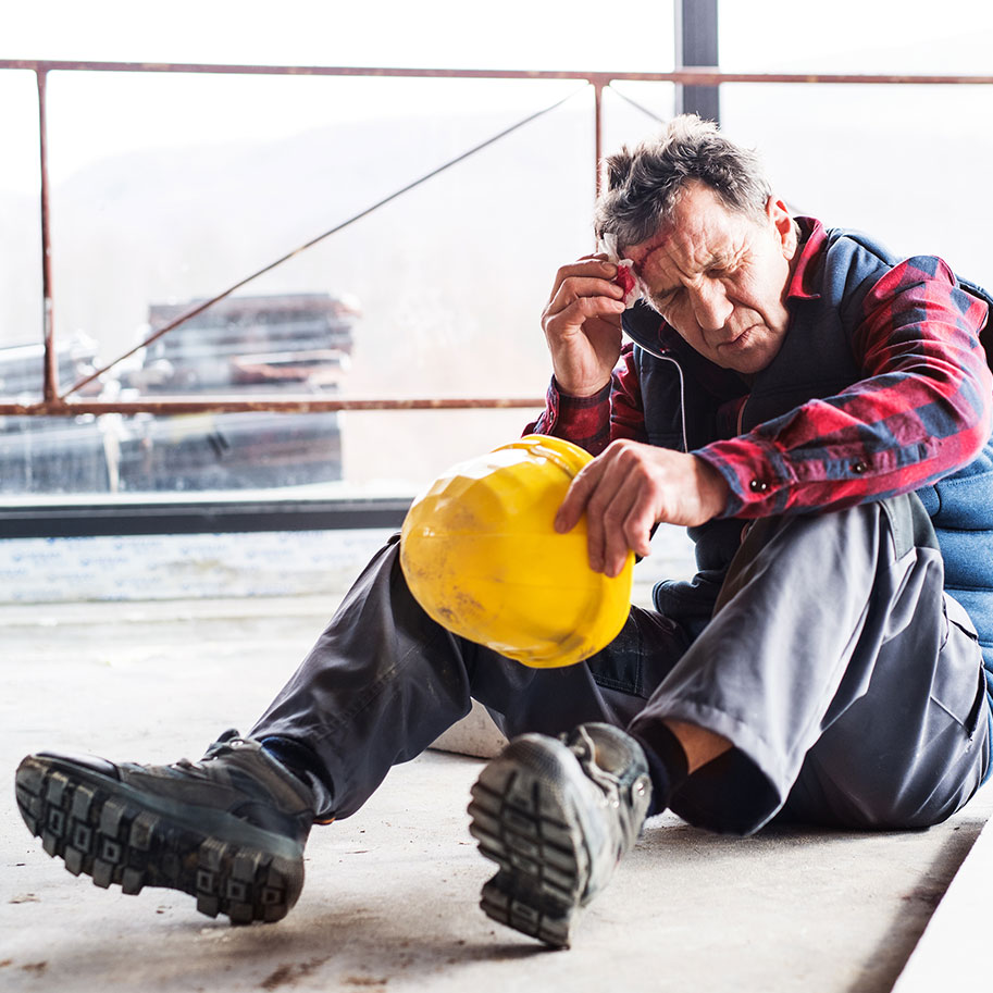 A construction worker with a head injury sits against a wall while another worker makes a phone call. When you need workers’ compensation for head injuries, Horenstein, Nicholson & Blumenthal attorneys help you through the process.