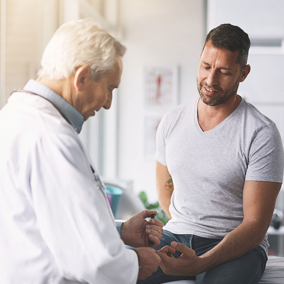 A man sits on a medical exam table talking to a doctor. After a slip-and-fall injury, get an attorney from Horenstein, Nicholson & Blumenthal to help secure every form of compensation available to you.