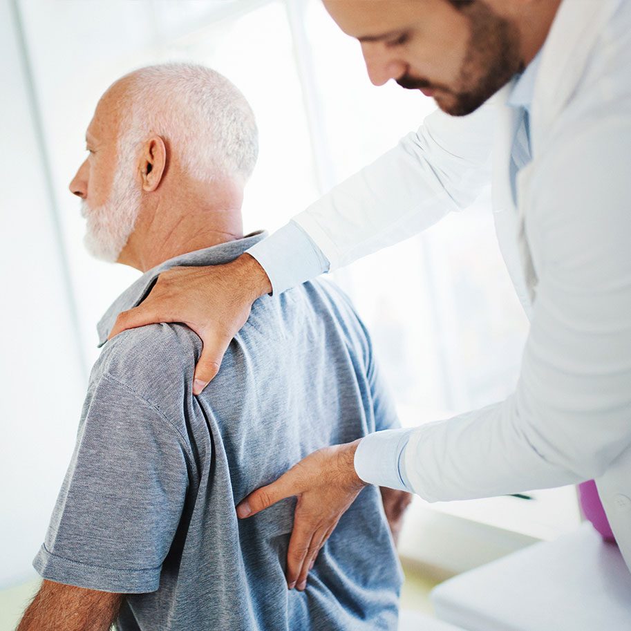 A doctor examines a man’s back. When you need workers’ compensation for spinal injuries, Horenstein, Nicholson & Blumenthal attorneys help you through the process.