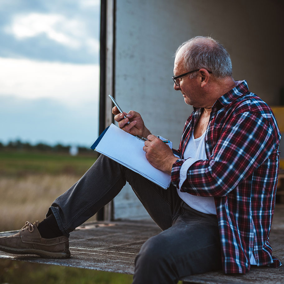 A man sits on the tailgate of a shipping truck, writing in a log book. The transportation workers’ compensation lawyers at Horenstein, Nicholson & Blumenthal help you navigate the benefits system.