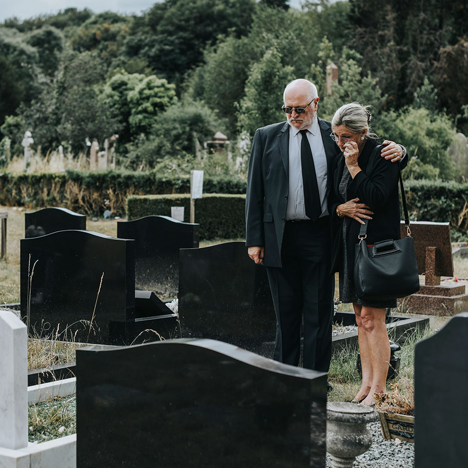 A man and woman stand in a cemetery looking at a gravesite. Horenstein, Nicholson & Blumenthal can help you understand whether you’re qualified for compensation after losing a family member to wrongful death.